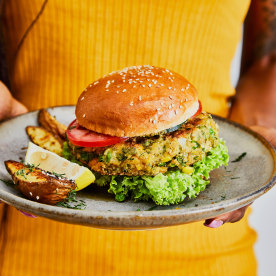 A woman holds a healthy vegan burger.