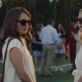 Gracie and Elizabeth stand facing each other wearing matching white shirts 