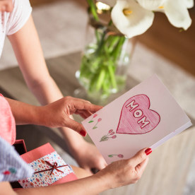 Family reading homemade Mother's day card together