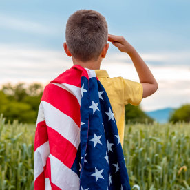 A young boy giving a salute to the US military and for Memorial Day