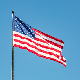 The US flag flying against a clear blue sky
