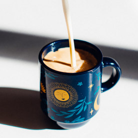 Creamer Pouring in Espresso Cup.