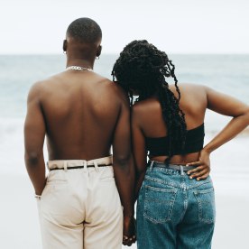 Shot of a young couple holding hands at the beach