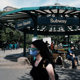 people walking around union square subway station with mask. 