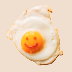 Fried eggs with anthropomorphic smiley faces on yolks