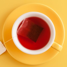 Yellow tea cup on a yellow background.
