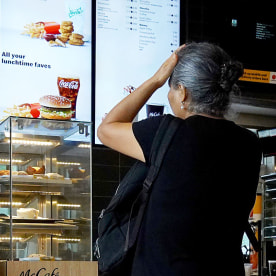 A customer waits to order food at a  McDonalds fast food restaurant on July 26, 2022 in Miami, Florida. 
