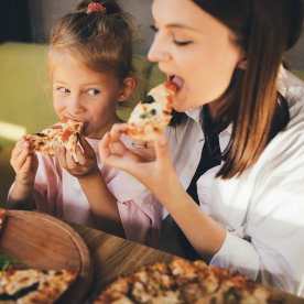 Mother and daughter eat pizza