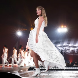 Taylor Swift in white dress on stage at Eras Tour.