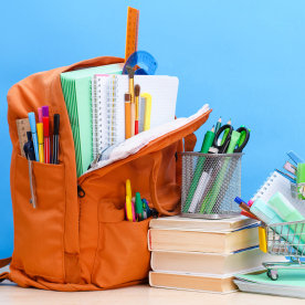 Orange school backpack full of school supplies.