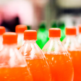 Bottles of orange soda in a supermarket.