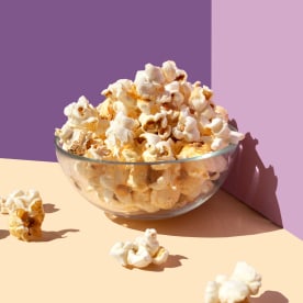 Popcorn bowl on the purple-beige background- frontal view