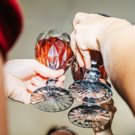 Female friends celebrate and drink red sparkling wine