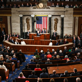 House members seated inside of the House Chamber room, Joe Biden speaks at the podium in the center