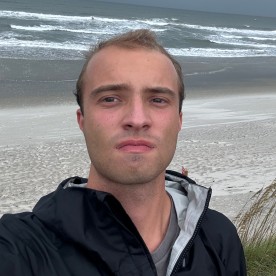 Ethan Clark, Owner and Founder of North Carolina's Weather, looks out on gloomy beach in North Carolina.