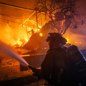 A Firefighter fights the flames from the Palisades fire.