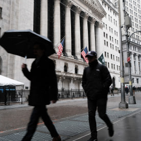 People walk through lower Manhattan by the New York Stock Exchange (NYSE) in light snow on March 14, 2023 in New York City. 