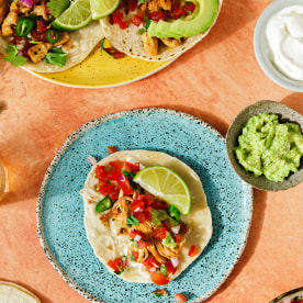 Top view shot of tacos with filling ingredients around on table.