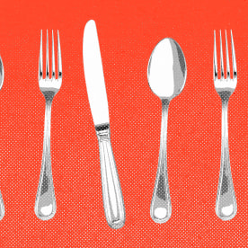 Forks, knives, and spoons lined up against a red background.
