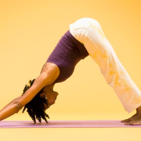 Woman in downward dog yoga stretch, side view