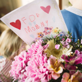 Little boy and girl with flowers and greeting card for mother