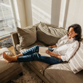 Woman enjoying a day off and reading a book on the couch