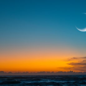 New moon or Ð¡rescent above ocean. Half Moon on bright evening sky, space for text