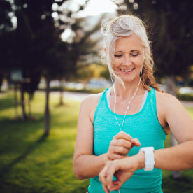 Athletic mature woman monitoring her running performance on smartwatch
