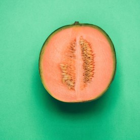 cantaloupe melon cut in half on green background