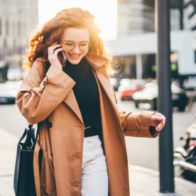 Woman walking and talking on the phone to improve mental health