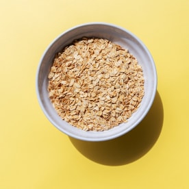 Oat Flakes in a Bowl Yellow Background