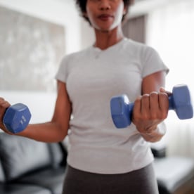 Woman exercising at home with dumbbells