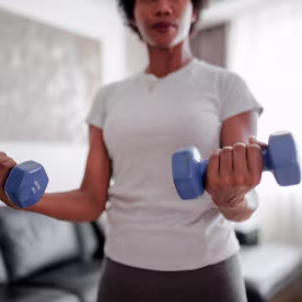 Woman exercising at home with dumbbells