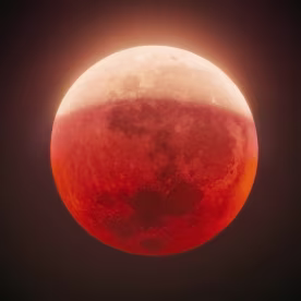Partial lunar eclipse casting red glow on Moon