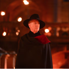 Alan Cumming stands in front of the castle in Episode 3 of "The Traitors: New Blood." 