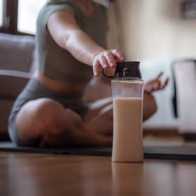 Young girl is hydrating during exercise in living room at home.