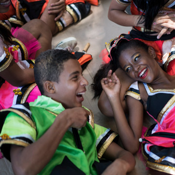 Image: Young revelers joke with each other as they lay on the shade during the \"Burial of the Mosquito\" carnival