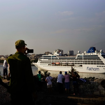 Image: Cuban soldiers watch the Carnival Adonia cruise ship arrive from Miami