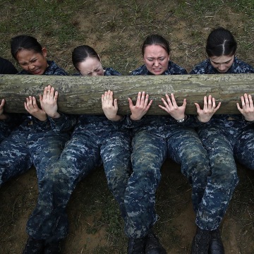 Image: Female Naval Academy plebes perform push ups with a twelve foot log