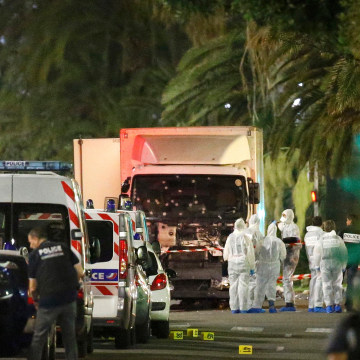 Image: French police forces and forensic officers stand next to a truck that ran into a crowd celebrating the Bastille Day national holiday on the Promenade des Anglais killing at least 60 people in Nice