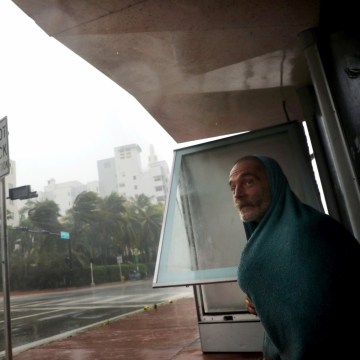 Image: A homeless man takes shelter at a bus stop in Miami Beach on Sept. 10.