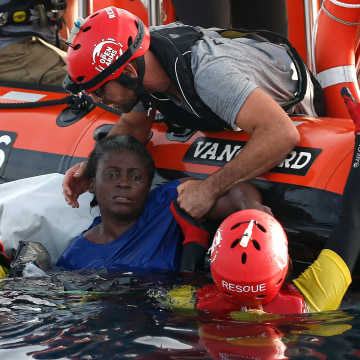 Image: Members of the Spanish NGO Proactiva Open Arms rescue a woman in the Mediterranean