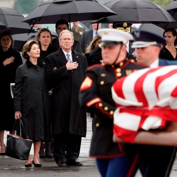 Image: Former President George W. Bush and former First Lady Laura Bush watch as the casket of former President George H.W. Bush is carried to a Union Pacific train following his funeral in Spring, Texas, on Dec. 6, 2018.