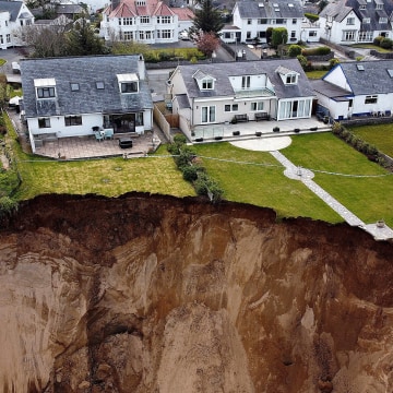 Image: Rockfall is seen on a beach after a cliff collapsed in the village of Nefyn, Wales.