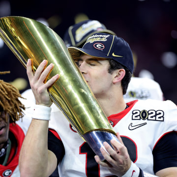 Stetson Bennett #13 of the Georgia Bulldogs celebrates with the National Championship trophy after the Georgia Bulldogs defeated the Alabama Crimson Tide 33-18 during the 2022 CFP National Championship Game at Lucas Oil Stadium on January 10, 2022 in Indi