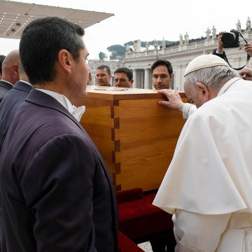Pope Francis touches the coffin of late Pope Emeritus Benedict XVI after his funeral mass in St. Peter's Square at the Vatican, Thursday, Jan. 5, 2023.