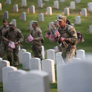 Members of the 3rd U.S. Infantry Regiment place flags at the headstones of U.S. military personnel buried at Arlington National Cemetery, in preparation for Memorial Day, on May 25, 2023 in Arlington, Virginia. More than 1000 service members entered the c
