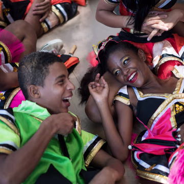 Image: Young revelers joke with each other as they lay on the shade during the \"Burial of the Mosquito\" carnival