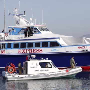 Image: A boat carrying migrants arrives in the Turkish coastal town of Dikili