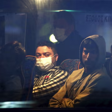 Image: Migrants on a bus before boarding a Turkish-flagged passenger boat to be returned to Turkey, on the Greek island of Lesbos